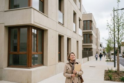 Façade d'un immeuble neuf à Choisy-le-Roi avec une résidente devant l'entrée principale